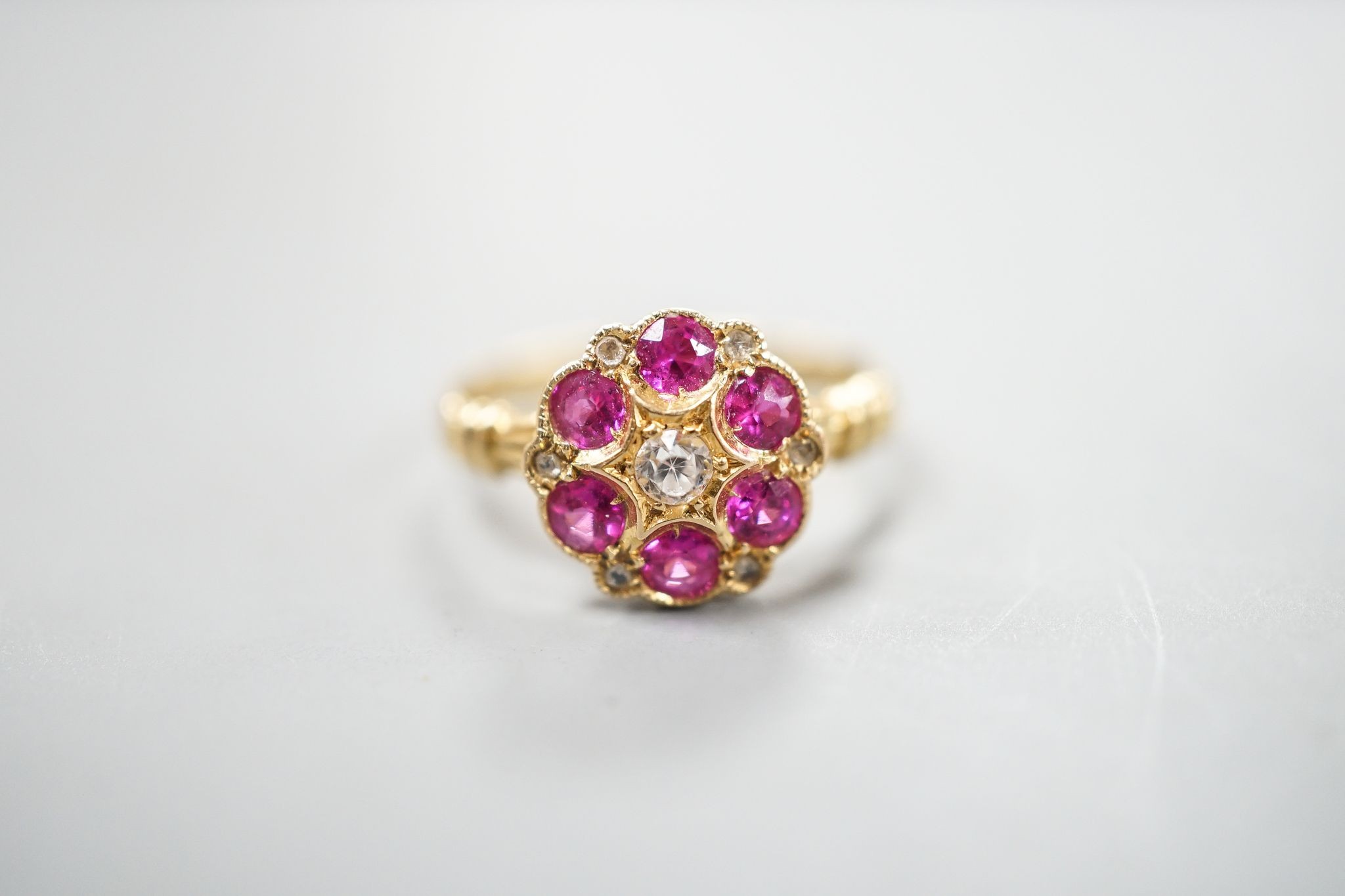 A George V 18ct gold, synthetic ruby, white sapphire? and diamond chip set cluster ring, size K, gross weight 2.4 grams.